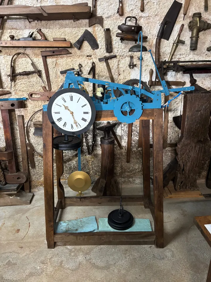 Mécanisme d’horloge d’édifice peint en bleu, avec son cadran et son balancier